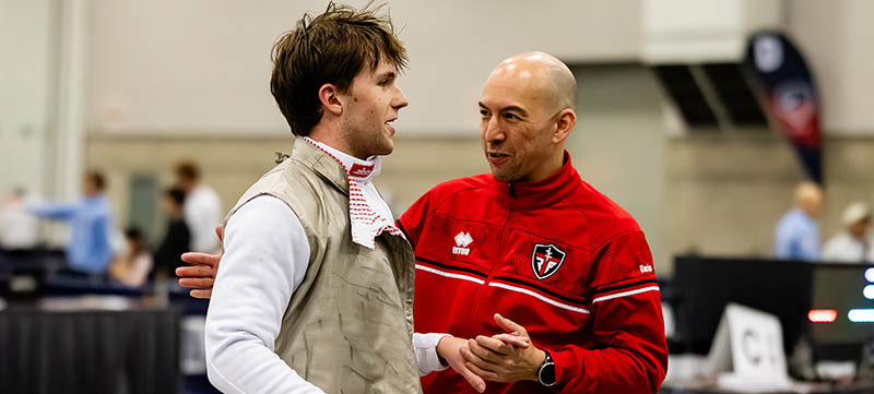 Ben and his coach embracing after his event