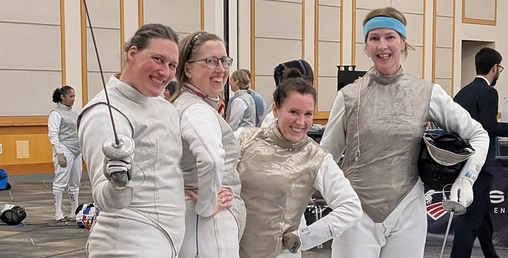 Four RTF veteran fencers smiling together in their whites